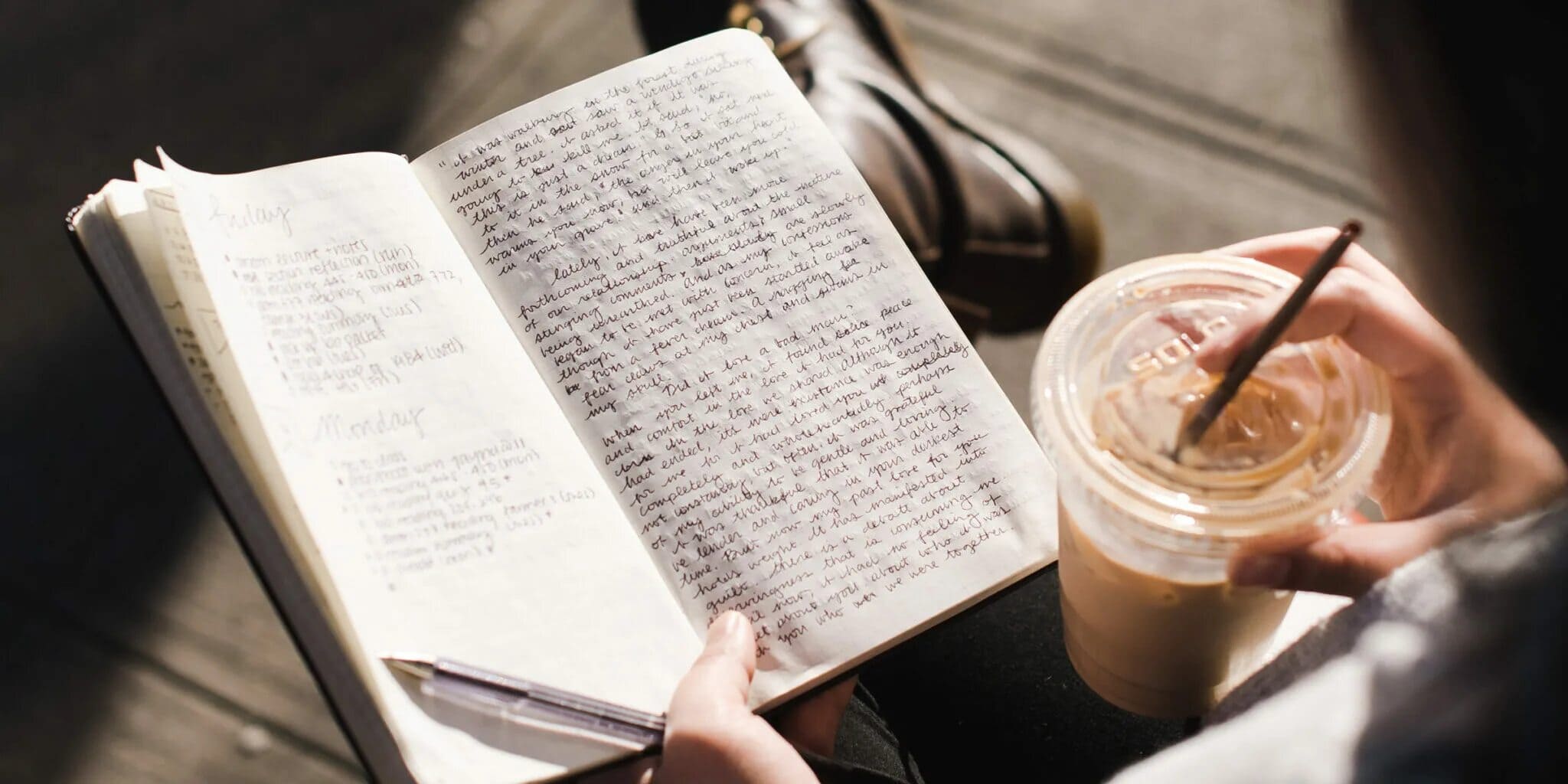 A person journaling with a cup of coffee.