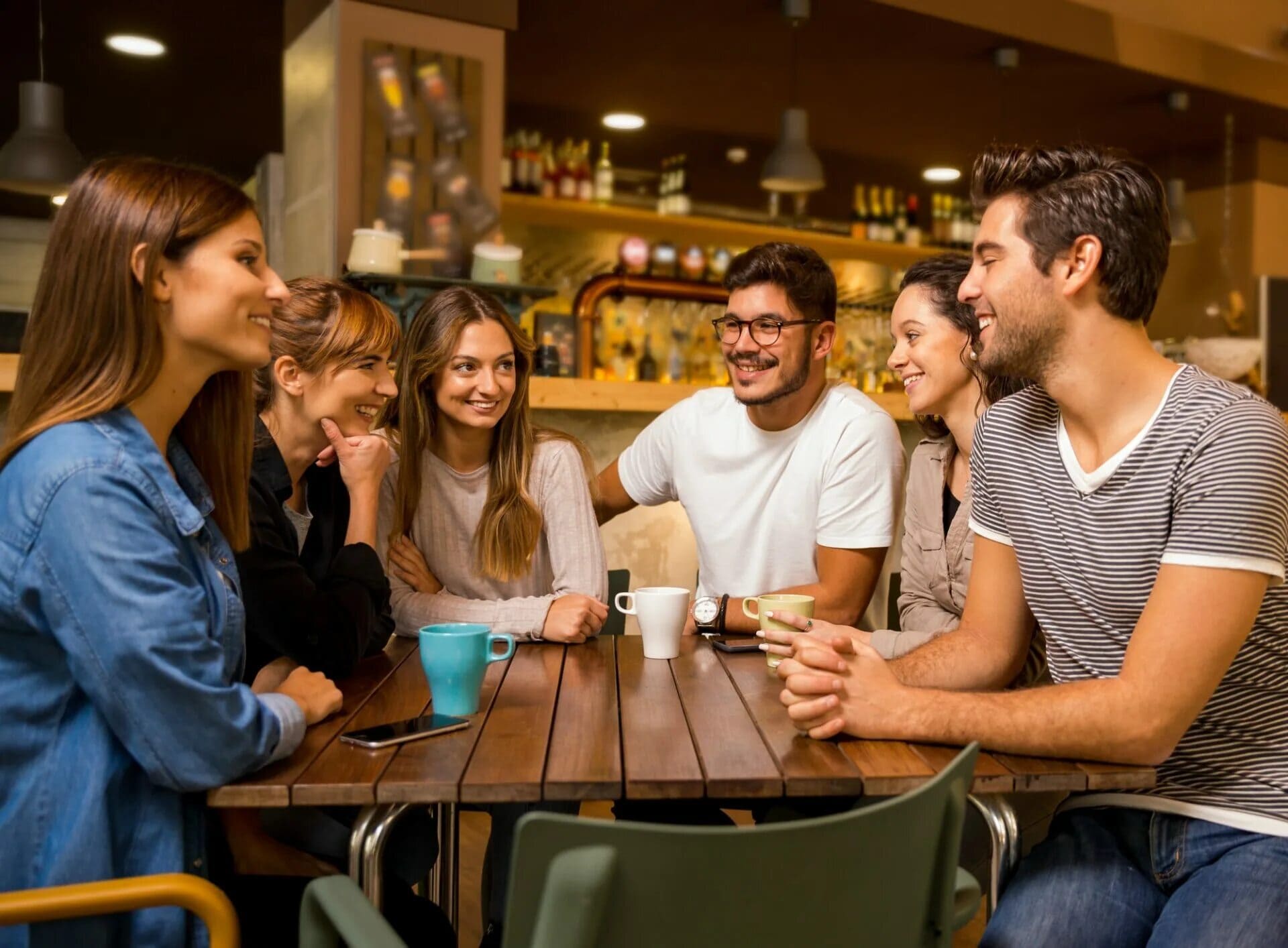 A group of smiling friends in a small town cafe.